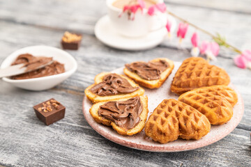 Homemade waffle with chocolate butter on a gray wooden. side view, selective focus.
