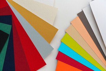 Colourful paper swatches on white desk, closeup detail