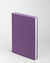  Purple diary in standing view on table on white background.