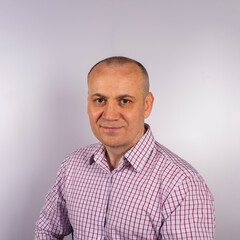 Fototapeta premium Portrait of a confident handsome well-groomed attractive cheerful positive cheerful man in a plaid business shirt highlighted on a white background