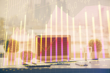 Forex graph hologram on table with computer background. Multi exposure. Concept of financial markets.