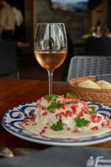 Chile en nogada con vino servido sobre tradicional plato de talavera