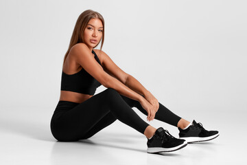 Fitness woman. Beautiful athletic girl, isolated on the gray background - obrazy, fototapety, plakaty