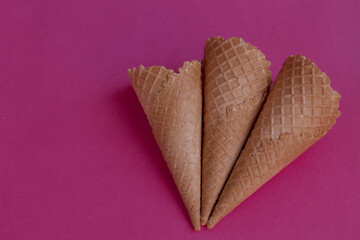 Collection of empty ice cream cones on pink color background