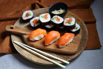 Fototapeta na wymiar Sushi and rolls with avocado and salmon on a wooden board.