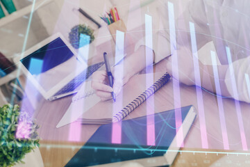 Financial graph displayed on woman's hand taking notes background. Concept of research. Double exposure