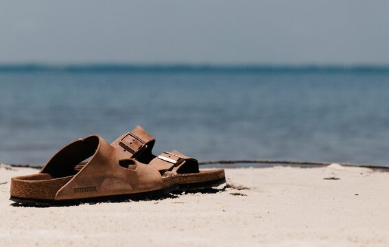 Selective focus shot of Birkenstock sandals on the beach