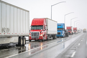 Long column of big rig semi trucks with semi trailers stands on the side of the highway due to a...