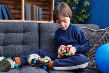 Down syndrome kid playing with puzzle cube at home