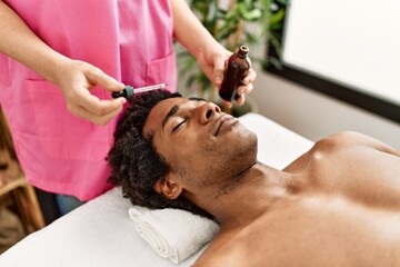 Young african american man having skin face treatment at beauty center