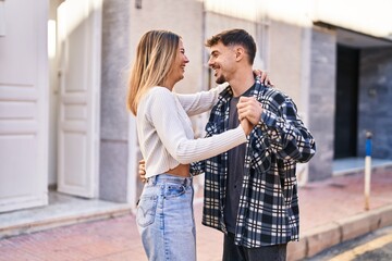 Naklejka premium Young man and woman couple smiling confident dancing at street