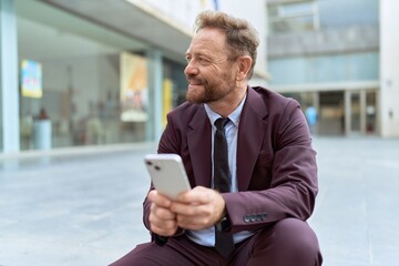 Middle age man business worker using smartphone sitting on stairs at street