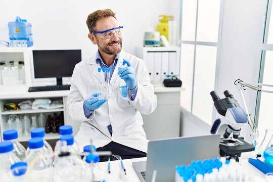 Middle age hispanic man wearing scientist uniform working at laboratory