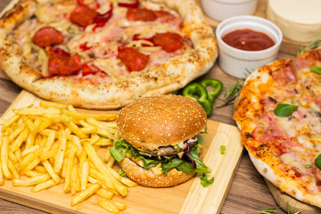 Pizza and hamburger on wooden background