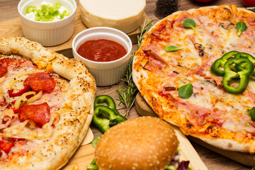 Pizza and hamburger on wooden background