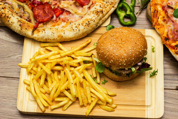 Pizza and hamburger on wooden background