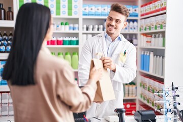 Man and woman pharmacist and client holding shopping bag at pharmacy