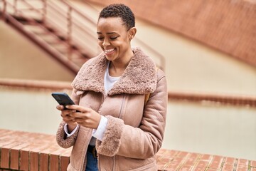 African american woman smiling confident using smartphone at street