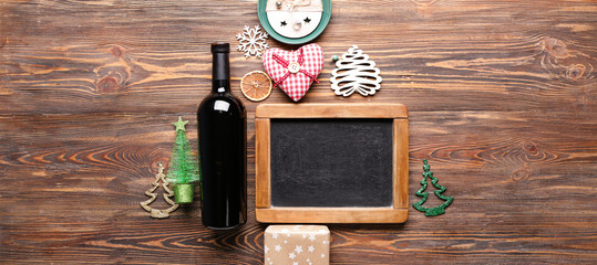 Christmas tree made of chalkboard, bottle of wine and decor on wooden background