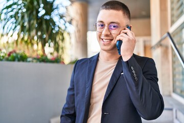 Young hispanic man executive smiling confident talking on smartphone at street