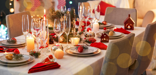 Stylish table setting with burning candles and Christmas decorations in room