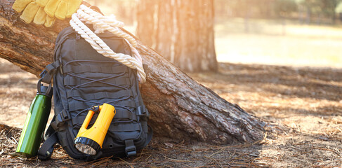 Tourist's backpack with survival kit in forest