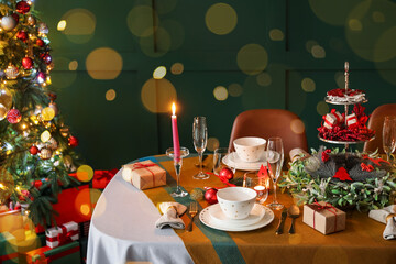 Romantic table setting for Christmas dinner at home in evening