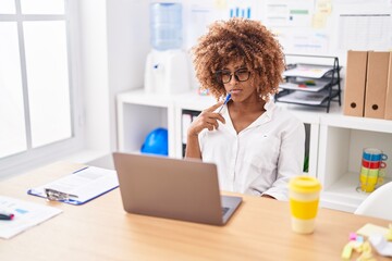 African american woman business worker using laptop with serious expression at office