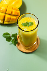 Fresh Mango Juice. Served with a natural green background color along with sliced ​​Arumanis mango.