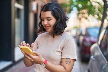 Young woman smiling confident using smartphone at street