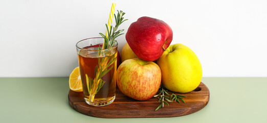 Ripe apples and glass of fresh juice on table