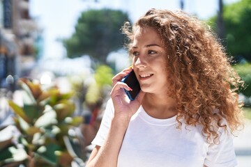 Young beautiful hispanic woman smiling confident talking on the smartphone at park