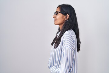 Young hispanic woman wearing glasses looking to side, relax profile pose with natural face and confident smile.