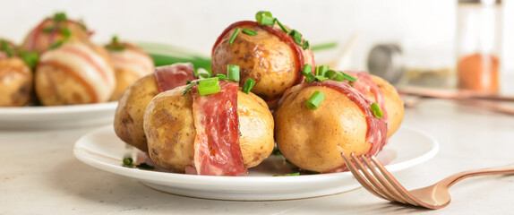 Plate of tasty baked potatoes with bacon on table, closeup