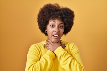 Fototapeta na wymiar Young african american woman standing over yellow background shouting and suffocate because painful strangle. health problem. asphyxiate and suicide concept.