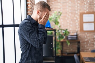 Young caucasian man business worker standing with arms crossed gesture and worried expression at office