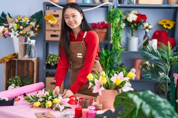 Young chinese woman florist make bouquet of flowers at flower shop