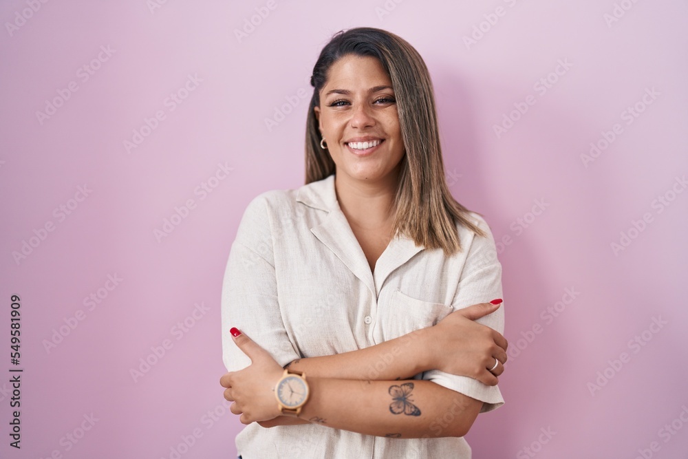 Poster blonde woman standing over pink background happy face smiling with crossed arms looking at the camer