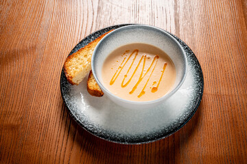 cream soup with toasts on wooden background