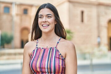 Fototapeta premium Young beautiful hispanic woman smiling confident looking to the side at street