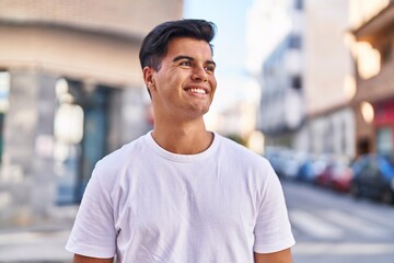 Fototapeta premium Young hispanic man smiling confident looking to the side at street