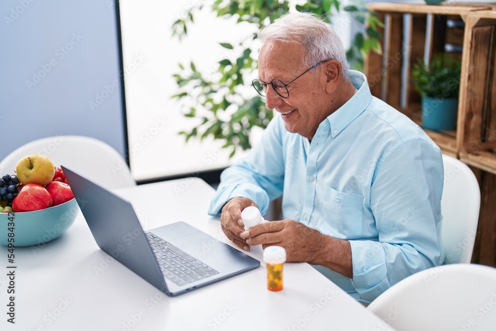 Poster senior grey-haired man having telemedicine sitting on table at home