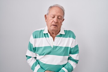 Senior man with grey hair standing over white background with hand on stomach because indigestion, painful illness feeling unwell. ache concept.