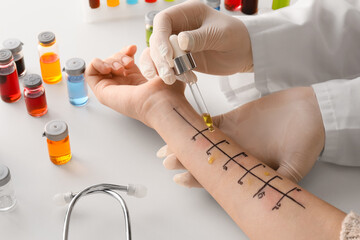 Doctor making allergy skin test on patient's hand in clinic, closeup - obrazy, fototapety, plakaty