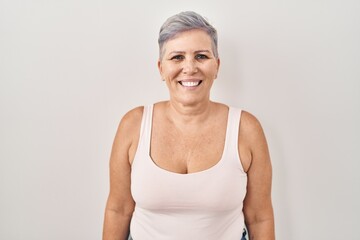 Middle age caucasian woman standing over white background with a happy and cool smile on face. lucky person.