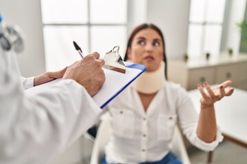 Man and woman doctor and patient having medical consultation for accident at clinic