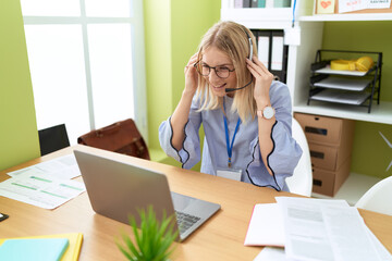 Young blonde woman call center agent smiling confident working at office