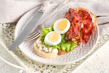 Fototapeta na wymiar Plate of delicious toast with boiled egg and fried bacon on light background, closeup