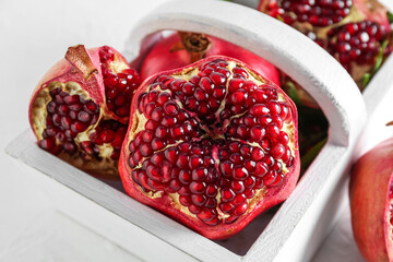 Basket of fresh pomegranates on light table, closeup