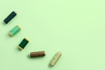 Set of thread spools on green background
